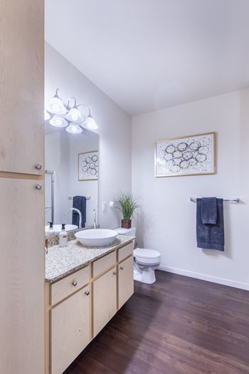 A bathroom with a toilet, sink, and mirror.